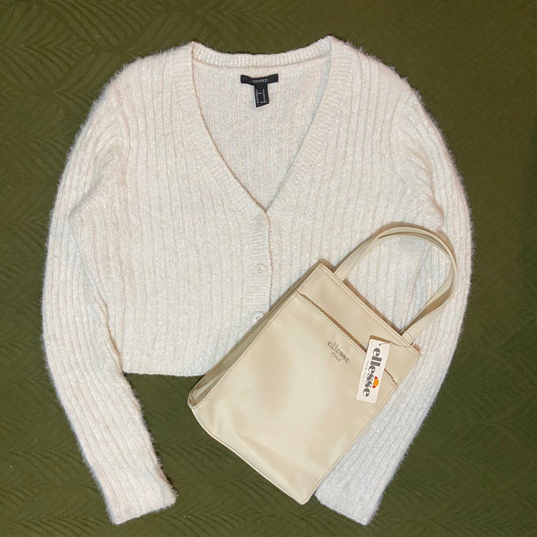 Forever 21 Cardigan & Ellesse Handbag (Category: Coats, Jackets and Outerwear) located in Manila. Submitted by goldenturtle.bfdfc0 (Listing ID 1416221602, Image 1). Description: - Bundle includes: - Cream Forever 21 cropped cardigan (V-neck, button closure) - Cream Ellesse tote bag (with zipper pocket, brand new with tag) - Dimensions: Chest - 19 inches / Length - 18 inches / Shoulder - 16 inches / Sleeves - 26 inches Location : Pasay City Lalamo