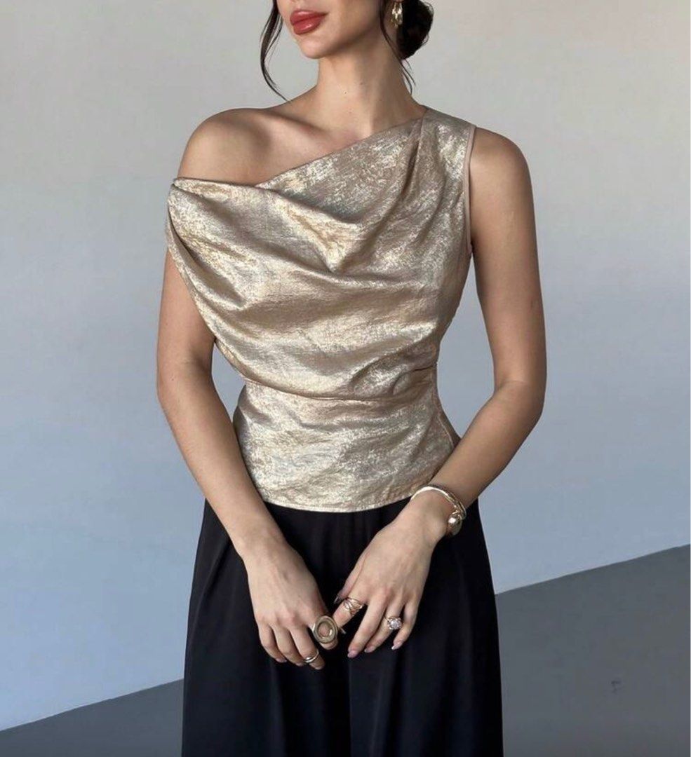 Gold One-Shoulder Top (Category: Sleeveless) located in Tanauan. Submitted by kdcstro (Listing ID 1416368677, Image 1). Description: - Worn once (christmas 2025) - Gold one-shoulder top - Draped design - Tie-back detail - Sleeveless - Asymmetrical neckline - Shimmering fabric - Ideal for special occasions.