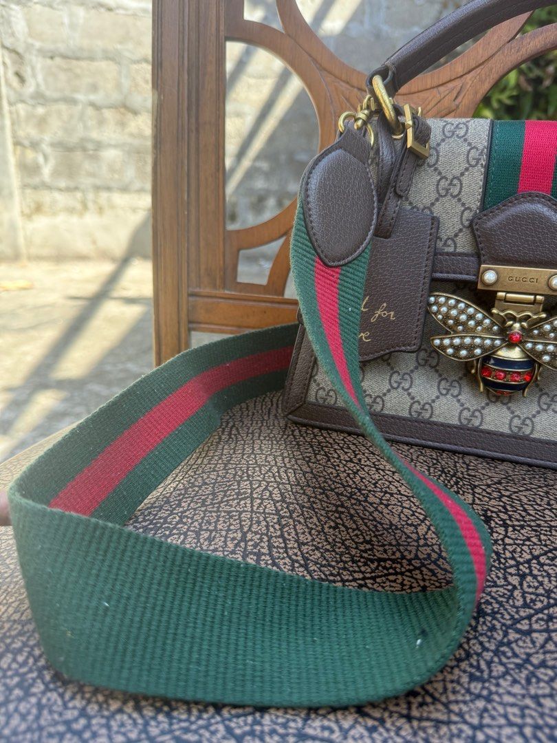 Gucci GG Marmont Bee Top Handle Bag (Category: Luxury Bags & Wallets) located in General Santos City (Dadiangas). Submitted by iluxxetosell (Listing ID 1416227619, Image 2). Description: - Gucci handbag - Iconic GG monogram canvas - Bee embellishment on front - Top handle - Detachable shoulder strap with green and red stripes - Interior: Main compartment and slip pocket - Features a 'Blind for Love' tag.