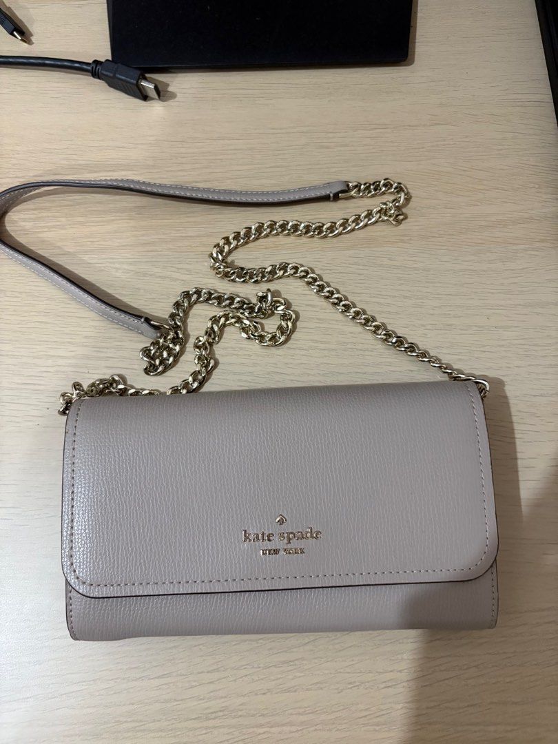 Kate Spade clutch bag (Category: Luxury Bags & Wallets) located in Manila. Submitted by isabellehm (Listing ID 1416243450, Image 1). Description: - Kate Spade wallet - Chain strap - Flap closure - Multiple card slots - Zippered compartment - Kate Spade New York logo - Solid, neutral color.