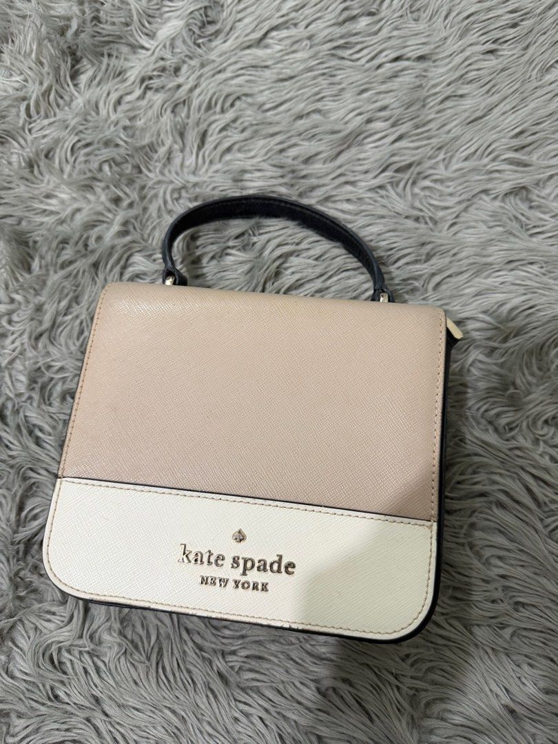 Kate Spade New York Handbag (Category: Luxury Bags & Wallets) located in Cabanatuan. Submitted by bianca00 (Listing ID 1416333568, Image 1). Description: - Kate Spade handbag - Dual-tone design: beige top, white bottom - Top handle - Magnetic closure - Beige interior - Black trim - Kate Spade New York logo on front.