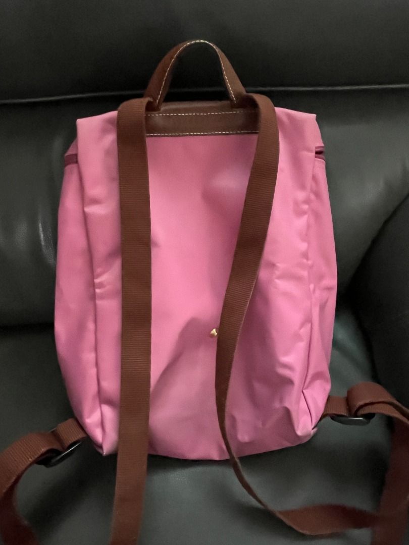 Longchamp Le Pliage Backpack Pink (Category: Luxury Bags & Wallets) located in Marikina City. Submitted by declutteringaccount__ (Listing ID 1416317121, Image 2). Description: Authentic‼️ Longchamp Le Pliage Backpack - Pink nylon body - Brown leather flap and handle - Adjustable brown straps - Gold-toned zipper and button - Classic design - Some signs of use but can be cleaned Negotiable within reason. I can do meet ups (QC-Marikina, Makati-BGC) 