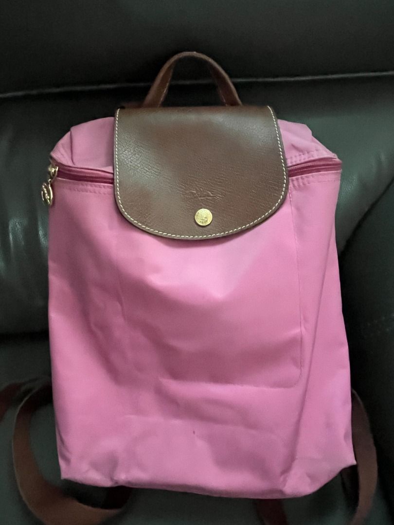 Longchamp Le Pliage Backpack Pink (Category: Luxury Bags & Wallets) located in Marikina City. Submitted by declutteringaccount__ (Listing ID 1416317121, Image 1). Description: Authentic‼️ Longchamp Le Pliage Backpack - Pink nylon body - Brown leather flap and handle - Adjustable brown straps - Gold-toned zipper and button - Classic design - Some signs of use but can be cleaned Negotiable within reason. I can do meet ups (QC-Marikina, Makati-BGC) 