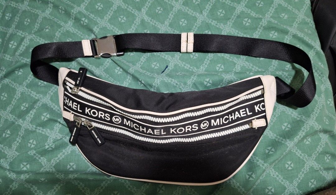 Michael Kors Kenly Medium Nylon Belt Bag (Category: Luxury Bags & Wallets) located in Manila. Submitted by natehiggers1 (Listing ID 1416345318, Image 1). Description: - Authentic Michael Kors fanny pack - Black with white accents - Adjustable black strap with silver buckle - Two zippered compartments - Black interior with Michael Kors logo - Includes care card and tag - Water and stain-resistant material Meetup in any Lrt/mrt stations shipping vi