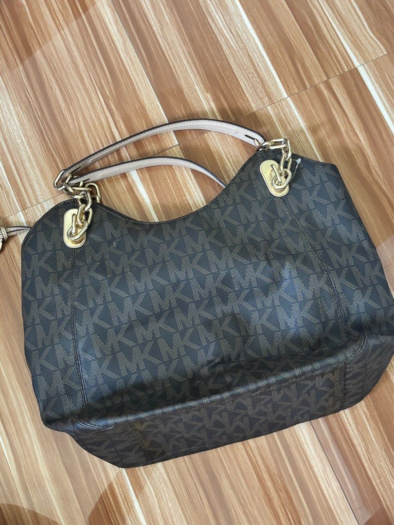 Michael Kors Authentic Monogram Tote Handbag Bag (Category: Luxury Bags & Wallets) located in Angeles City. Submitted by rawd3nim (Listing ID 1416271132, Image 3). Description: - Authentic Michael Kors handbag, a hand me down from my mom. - Features the iconic MK logo pattern - Comes with a detachable charm - Stylish chain strap - Elegant brown leather exterior - Luxurious gold-tone hardware - Light beige interior lining .