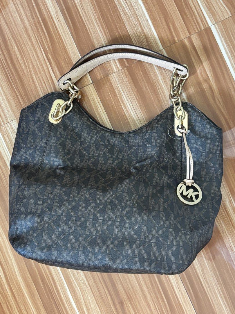 Michael Kors Authentic Monogram Tote Handbag Bag (Category: Luxury Bags & Wallets) located in Angeles City. Submitted by rawd3nim (Listing ID 1416271132, Image 1). Description: - Authentic Michael Kors handbag, a hand me down from my mom. - Features the iconic MK logo pattern - Comes with a detachable charm - Stylish chain strap - Elegant brown leather exterior - Luxurious gold-tone hardware - Light beige interior lining .