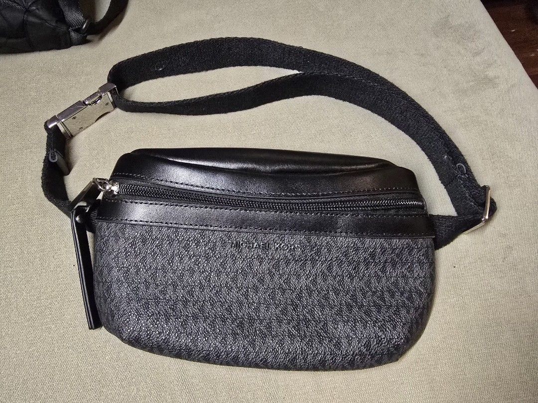 Michael Kors Waist Bag (Category: Luxury Bags & Wallets) located in Quezon City. Submitted by b.caster (Listing ID 1416300560, Image 1). Description: - Black Michael Kors waist bag - Zip closure - Adjustable strap - Features the Michael Kors logo pattern - Light beige interior - Metal buckle on strap.