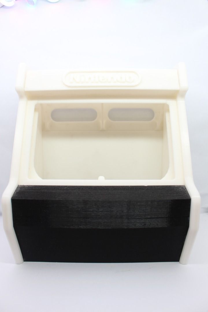 Nintendo Switch Arcade Cabinet (Category: Nintendo) located in Manila. Submitted by jjalbert (Listing ID 1416274202, Image 1). Description: - Miniature Nintendo Switch arcade cabinet - Features a cream-colored top and sides - Black front panel - Rectangular opening in the front - Nintendo logo visible - Decorative item - RFS: Dont need it - Note: Di po kasya ang switch OLED.