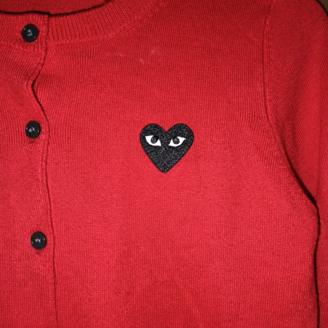 Play Comme des Garcons Red Cardigan (Category: Coats, Jackets and Outerwear) located in Goa. Submitted by kaye_dee (Listing ID 1416400240, Image 3). Description: - Play Comme des Garcons cardigan - Red color - Features black heart logo with eyes - Size M - Button-up front - Long sleeves.