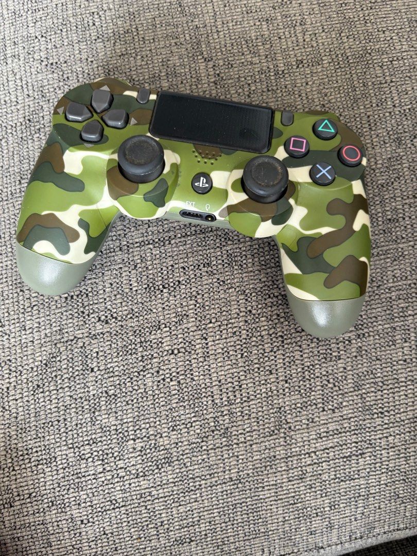PS4 controller (Category: Controllers) located in Singapore. Submitted by 28dxf6sycf74537 (Listing ID 1416281216, Image 1). Description: - Used Sony PlayStation 4 controller - Camouflage design - Buttons and joysticks show wear - Tested and fully functional - Perfect for gaming! Authentic controller selling at very cheap.