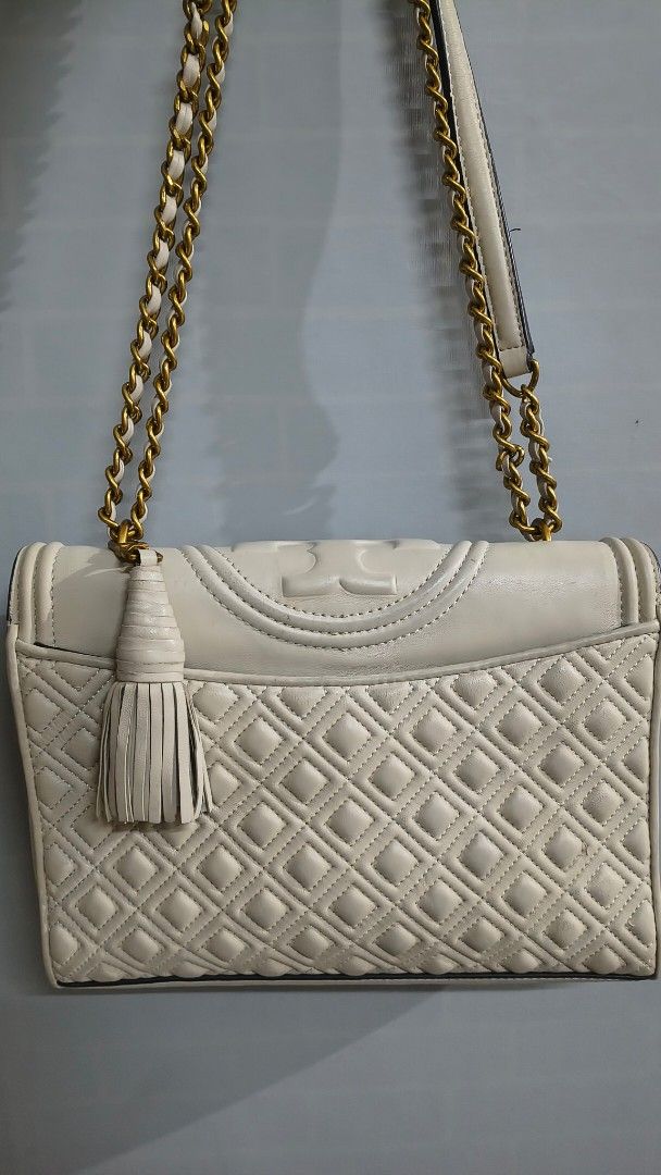 Tory Burch Kira Chevron Chain bag (Category: Luxury Bags & Wallets) located in Pasig City. Submitted by lfboutique (Listing ID 1416253716, Image 2). Description: - Tory Burch Kira Chevron Chain Wallet - Quilted design - Cream color with gold-tone hardware - Gold chain strap - Flap closure with Tory Burch logo - Tassel detail - Interior: multiple compartments and zip pocket sig of usage pasig loc.