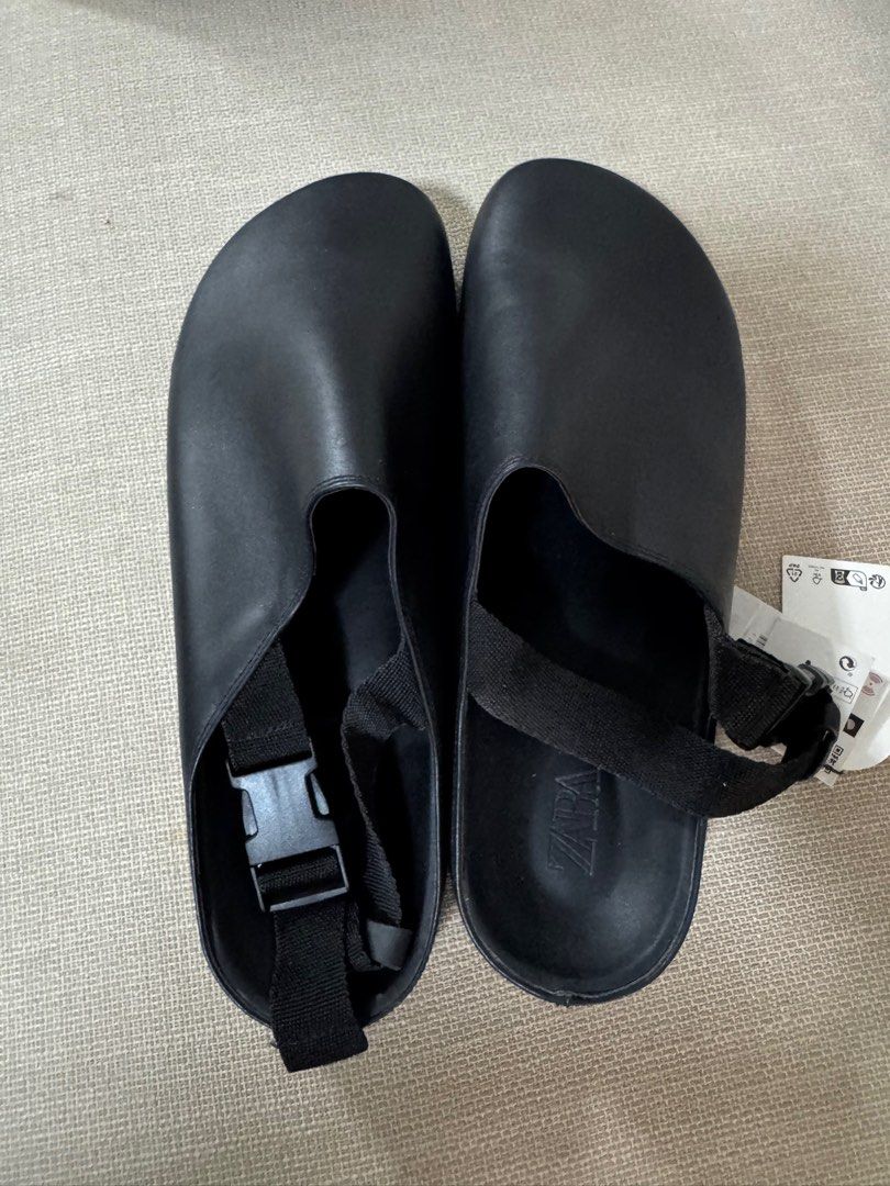 Zara Black Clogs with Straps (Category: Slippers & Slides) located in Taguig. Submitted by declutterme12 (Listing ID 1416221940, Image 2). Description: - Black Zara clogs - Adjustable straps - Rounded toe - Textured sole - Original tag included (4995 PHP) - Buckle closure - Black sole with white trim.