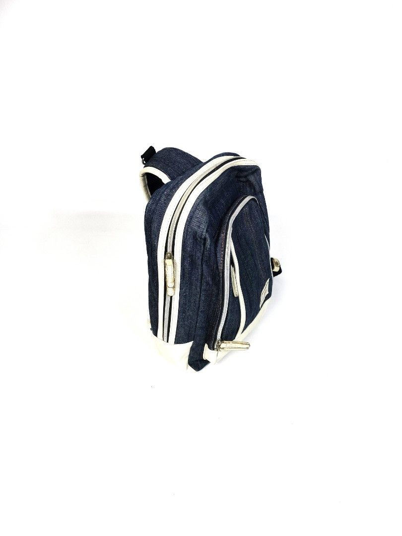 Alpha Industries Denim Leather BodyBag (Category: Backpacks) located in Manila. Submitted by callmetin (Listing ID 1416564056, Image 2). Description: Alpha Industries backpack features a denim exterior with white accents. It has a front pocket and a main compartment with a zipper closure. The backpack includes adjustable shoulder straps and a top handle. The interior lining is a dark green color. The Alpha Industries logo is visible on the front.