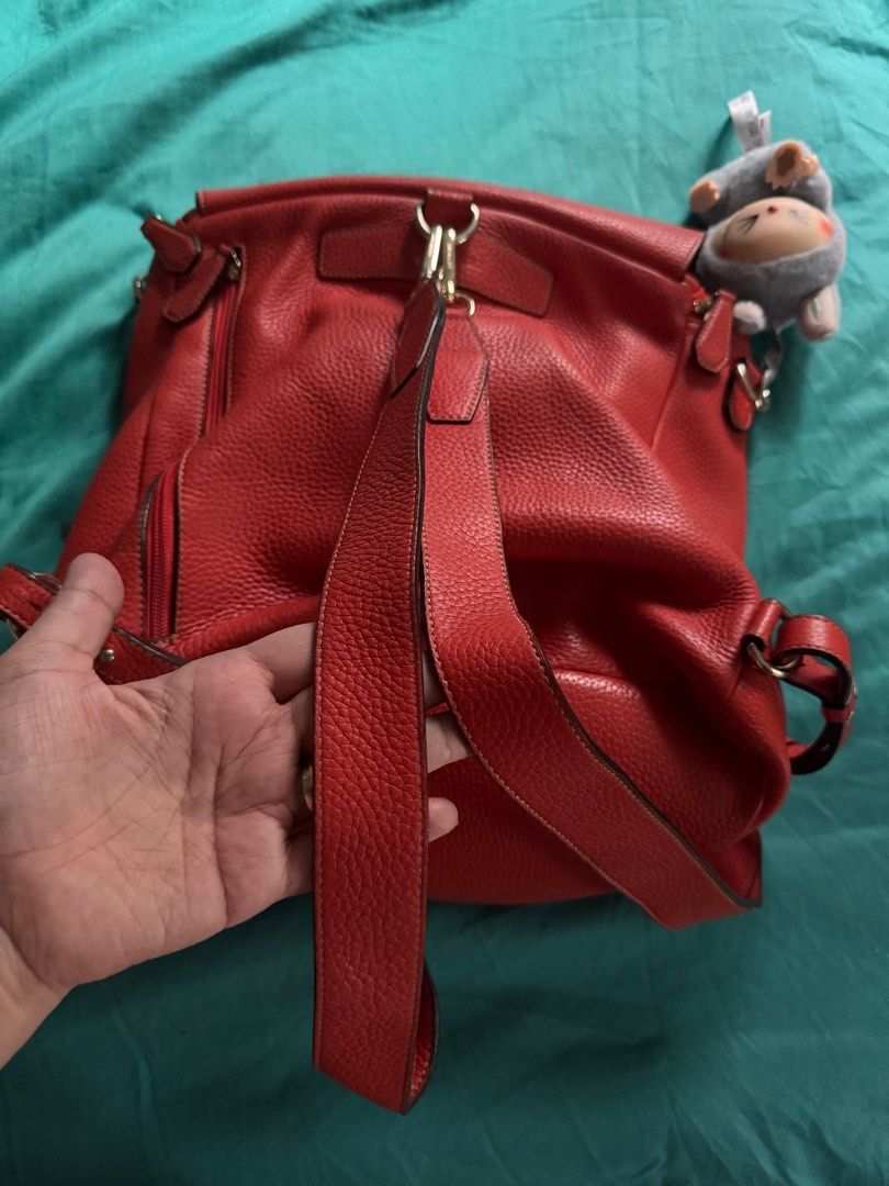 Bruno Magli Red Leather Backpack (Category: Backpacks) located in Las Pinas. Submitted by nautikath18 (Listing ID 1416570625, Image 2). Description: Stylish red leather backpack from Bruno Magli. Features a flap closure and adjustable straps. The interior includes a zippered pocket and a spacious main compartment. The bag has a textured leather exterior and gold-toned hardware. .