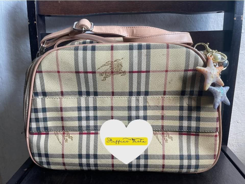 Burberry Checkered Shoulder Bag (Category: Luxury Bags & Wallets) located in Manila. Submitted by stuffiesyesha (Listing ID 1416516347, Image 2). Description: - Authenticity not Guaranteed, but galing Abroad. Burberry shoulder/Mini Traveling /Vanity bag - Iconic checkered pattern - Top handle and detachable shoulder strap - Secure zipper closure - Spacious interior - Elegant beige and brown color scheme - Luxurious leather trim - Includes a decor