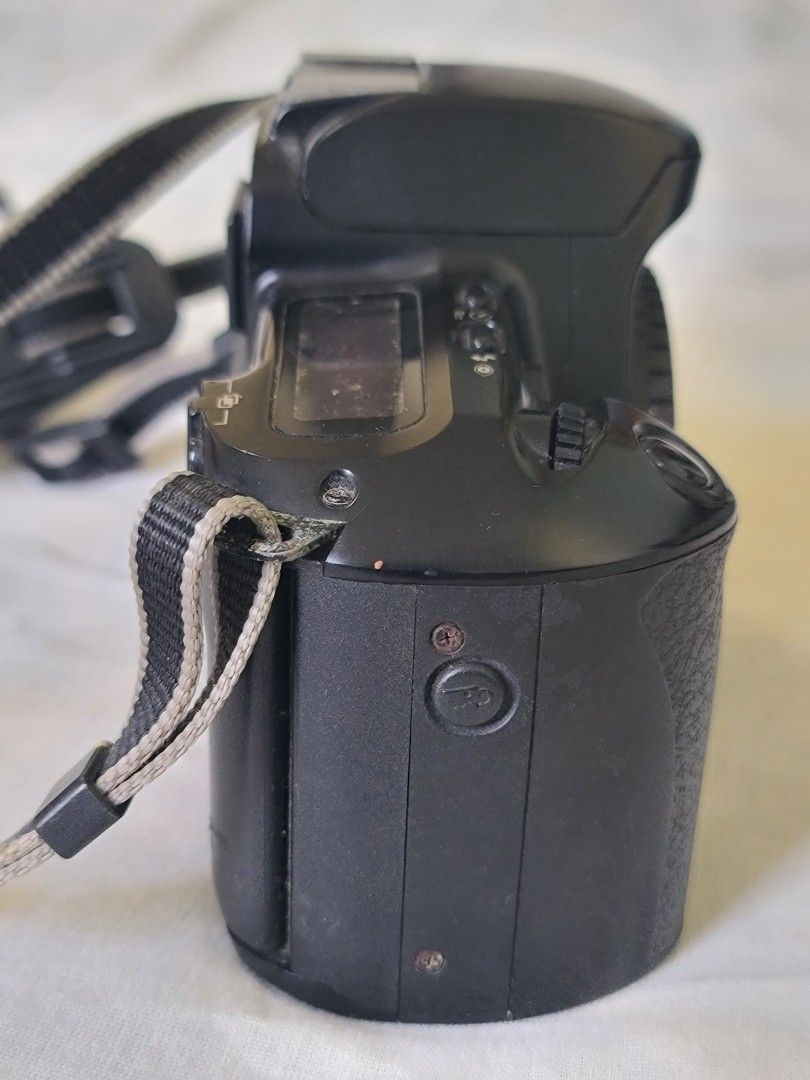 Canon EOS Kiss Camera (Category: Cameras) located in Manila. Submitted by gane_esla (Listing ID 1416502504, Image 3). Description: FOR COLLECTORS' USE ONLY. NOT WORKING - Canon EOS Kiss camera - Includes lens cap and strap - Features panorama mode - Black camera body - Viewfinder and control buttons.