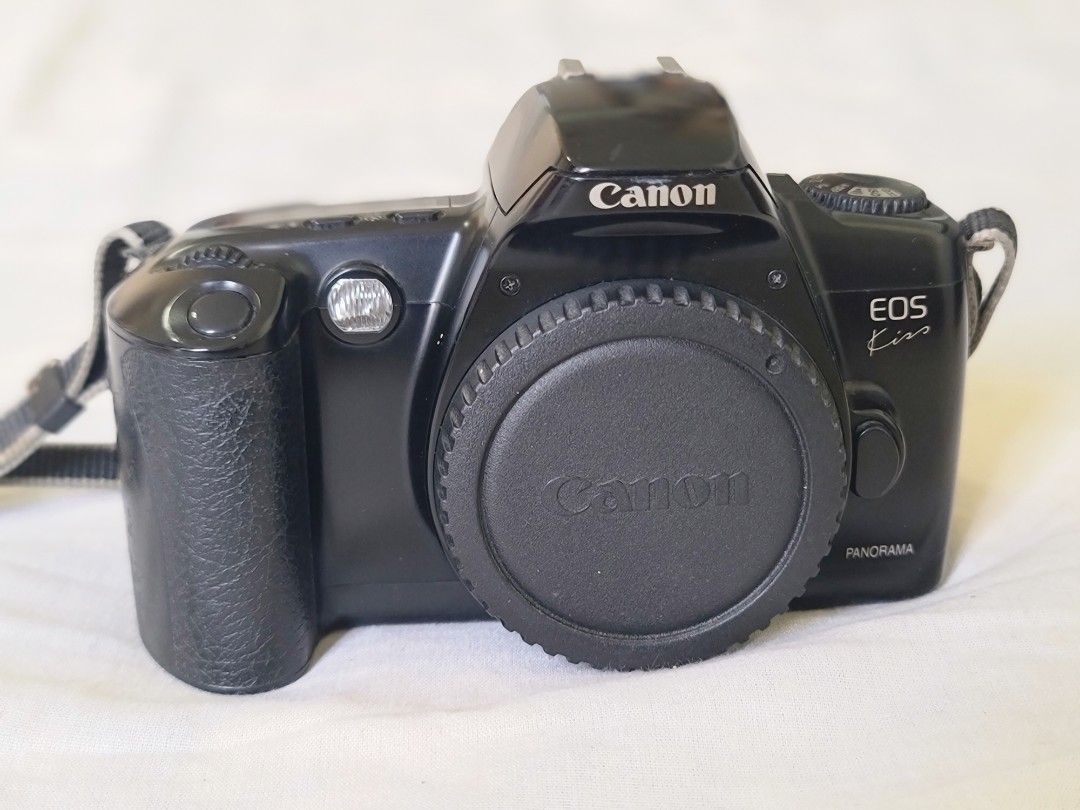 Canon EOS Kiss Camera (Category: Cameras) located in Manila. Submitted by gane_esla (Listing ID 1416502504, Image 1). Description: FOR COLLECTORS' USE ONLY. NOT WORKING - Canon EOS Kiss camera - Includes lens cap and strap - Features panorama mode - Black camera body - Viewfinder and control buttons.