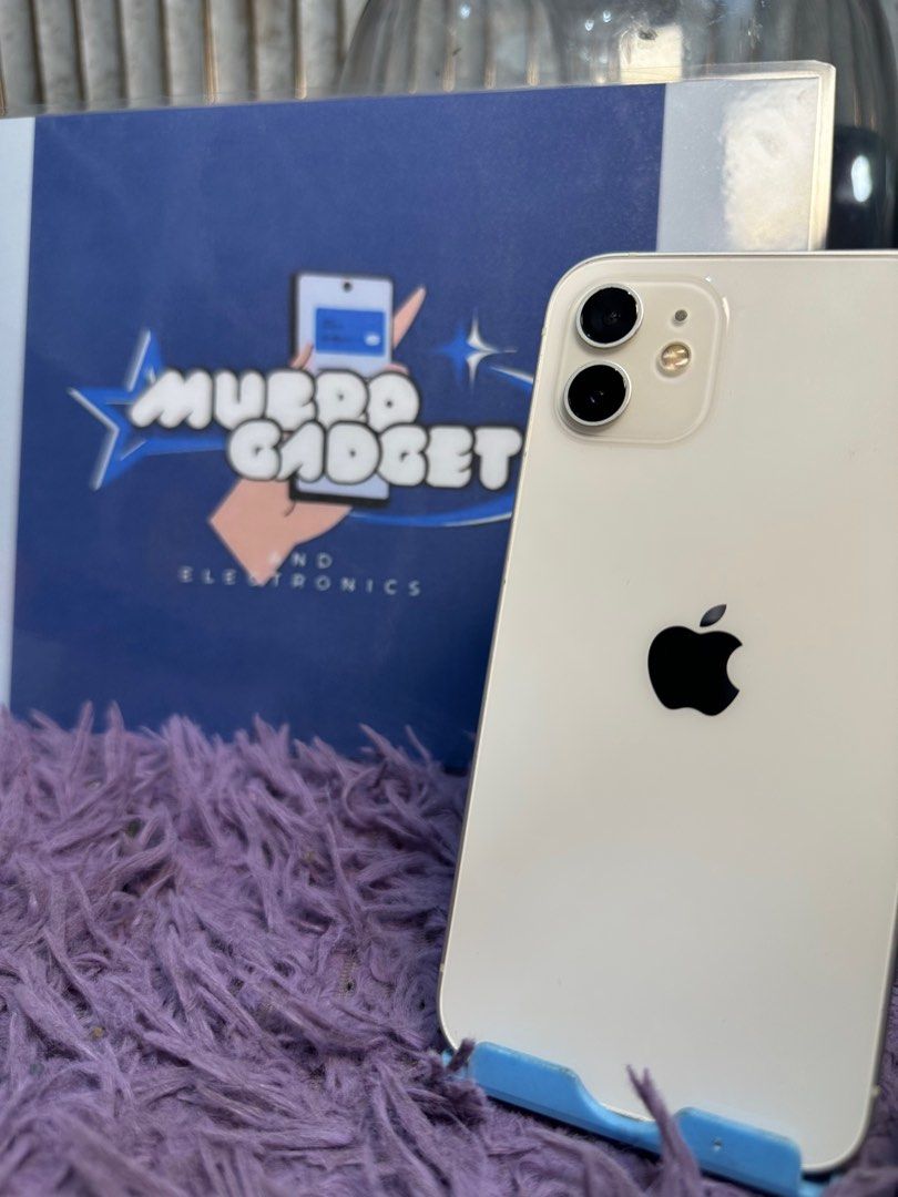 Iphone 12 (Category: iPhone 12 Series) located in Quezon City. Submitted by mubrogadgets (Listing ID 1416485604, Image 2). Description: FOR SALE: iPhone 12 🤍 (White) 💸 ₱12,800 na lang! Sulit deal! ✅ 64GB Storage – smooth pang-daily use ✅ No Issue / All Goods – tested, maayos gamitin ✅ NTC Approved – legit at safe gamitin sa PH 🔋 77% Battery Health – original battery, hindi palit ✨ Premium Design + Solid Performance 📸 Ganda ng camera – malinaw