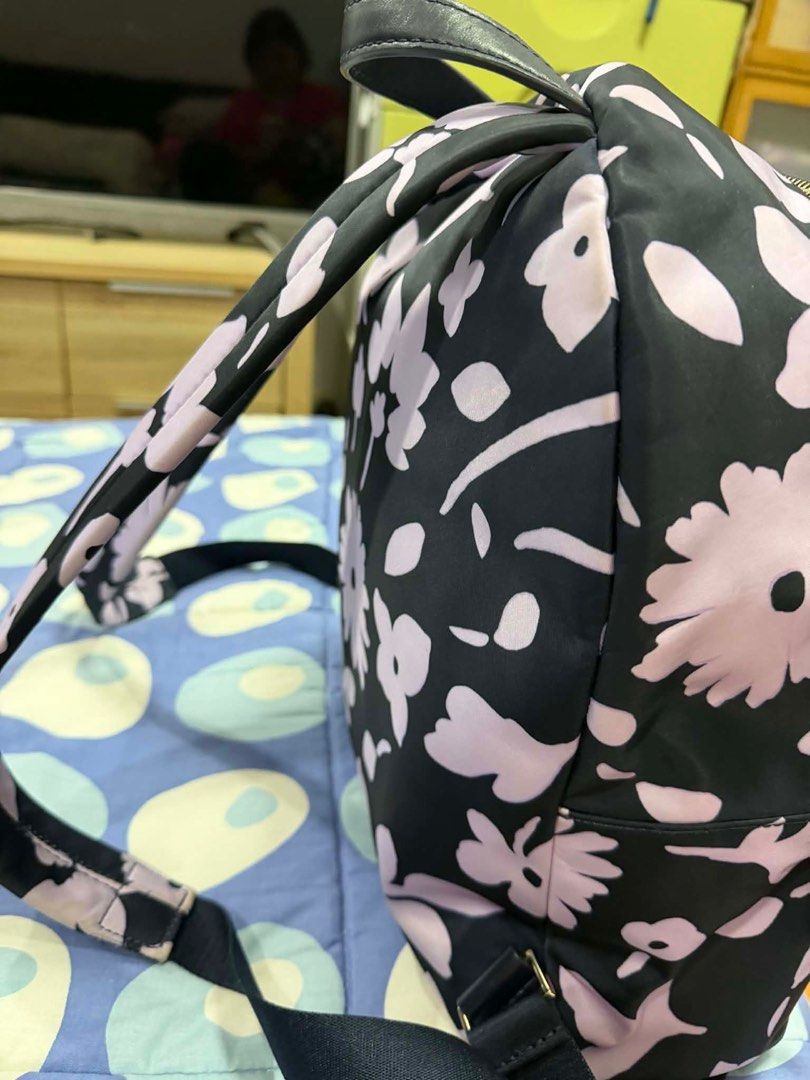 Kate Spade Floral Backpack (Category: Backpacks) located in Quezon City. Submitted by bertching (Listing ID 1416610790, Image 3). Description: - Black Kate Spade backpack - Light purple floral pattern - Front pocket with gold zipper - Gold hardware - Adjustable straps - Top handle - Kate Spade logo on front.