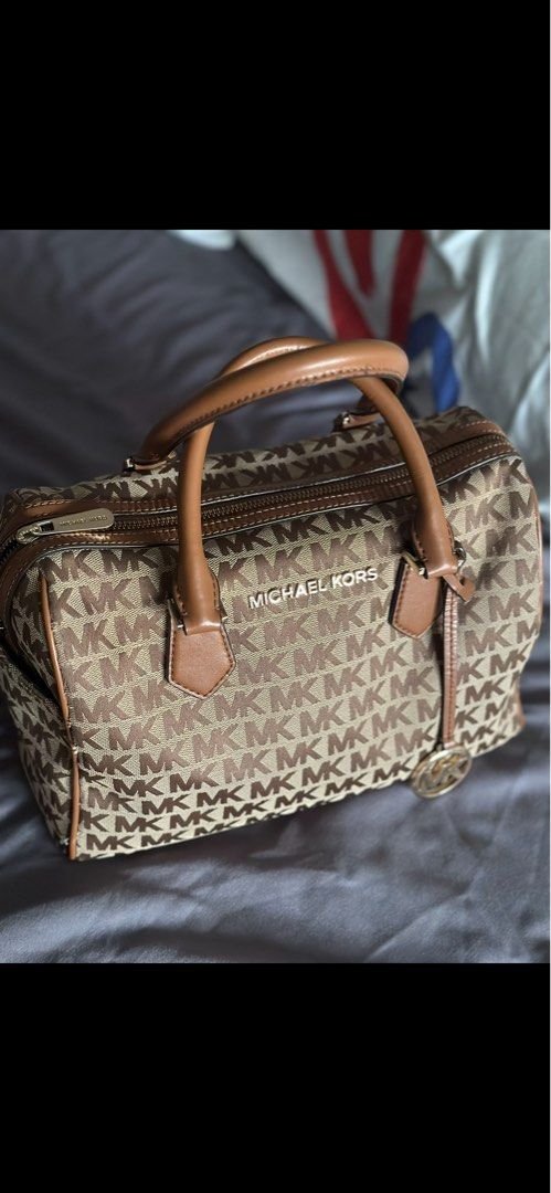 Michael Kors Handbag (Category: Luxury Bags & Wallets) located in Sual. Submitted by Twinkle (Listing ID 1416583253, Image 1). Description: - Authentic Michael Kors handbag - 30 × 16 × 20 cm Zip closure Double handle Adjustable & removable long strap Protective metal feet at base Metal logo lettering on front -lost sling.
