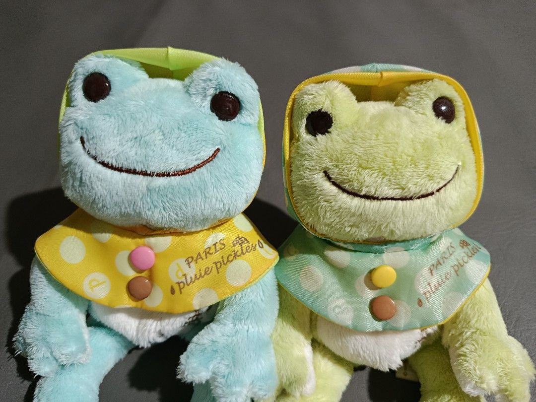 Pickles the Frog Paris Pluie Series (Category: Plushies & Soft Toys) located in Angeles City. Submitted by lnptoysandcollectibles (Listing ID 1416512197, Image 3). Description: - Cute Pickles the Frog plush toys - Features: - Polka-dot hood - Matching raincoat - Colors: Light blue and light green - Bib details: Button and "PARIS pluie pickles" print - Soft and cuddly material.