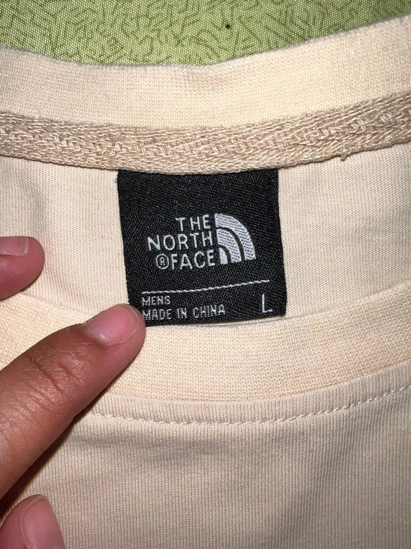 The North Face Beige Shirt (Category: Tshirts & Polo Shirts ) located in Quezon City. Submitted by declutteringpeppers (Listing ID 1416572554, Image 3). Description: - The North Face T-shirt - Dimes 18x24 in - Color: Beige - Men's size: Large - Features the North Face logo on the front - Graphic on the back with "Never Stop Exploring" text - Made in China.