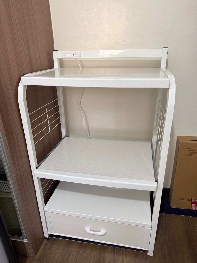 White Microwave Oven Rack with Drawer (Category: Ovens & Toasters) located in Taguig. Submitted by lalohan (Listing ID 1416584672, Image 2). Description: - White microwave oven rack - Features a drawer and two shelves - Includes a built-in power outlet - Sturdy metal frame - Wire side panels - Ideal for microwave ovens and other kitchen appliances - Perfect for kitchen use - Measurement: L64 x W42.5 x H109.5 cm Weight: 14.5 kg.