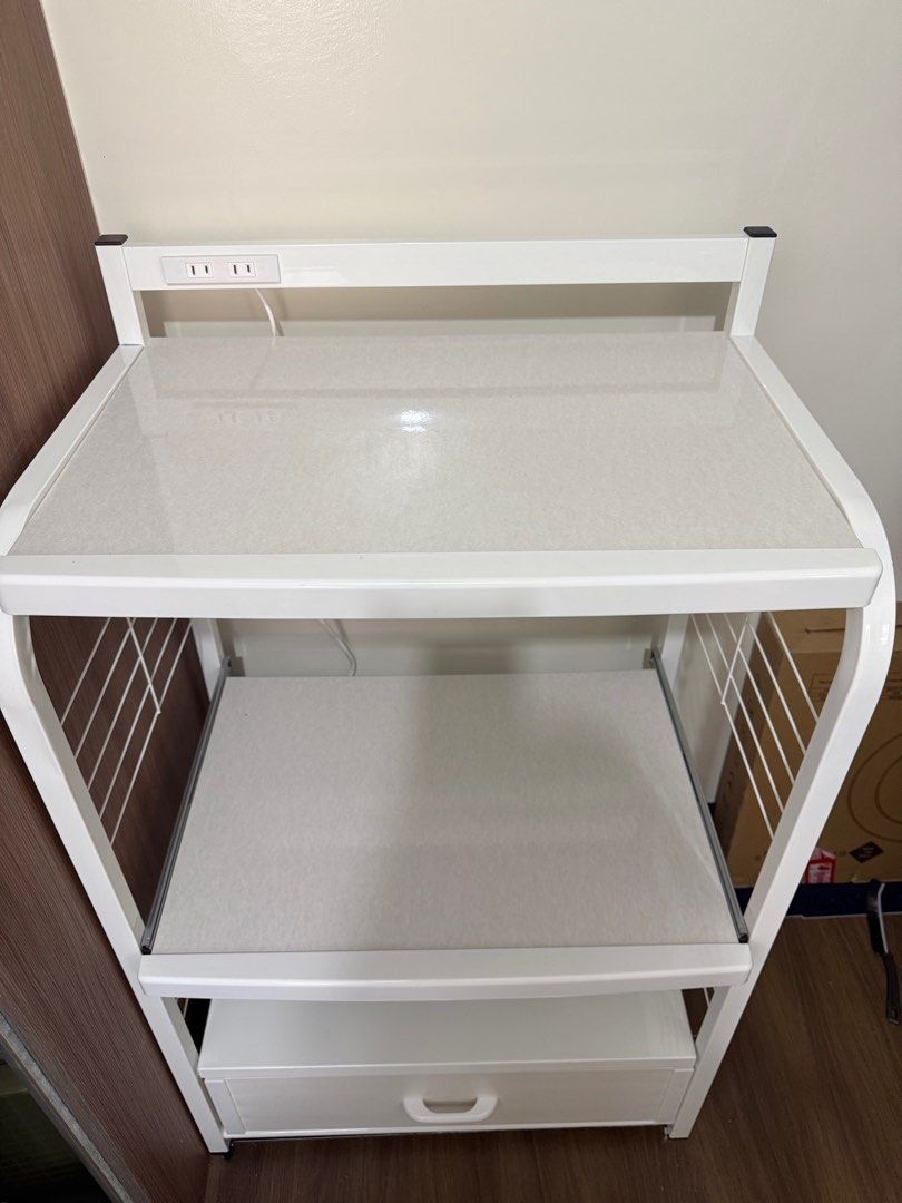 White Microwave Oven Rack with Drawer (Category: Ovens & Toasters) located in Taguig. Submitted by lalohan (Listing ID 1416584672, Image 3). Description: - White microwave oven rack - Features a drawer and two shelves - Includes a built-in power outlet - Sturdy metal frame - Wire side panels - Ideal for microwave ovens and other kitchen appliances - Perfect for kitchen use - Measurement: L64 x W42.5 x H109.5 cm Weight: 14.5 kg.