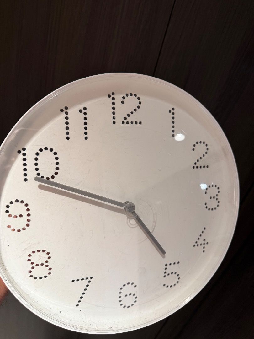 White Wall Clock (Category: Clocks) located in Singapore. Submitted by gerrard8571-8507 (Listing ID 1416497145, Image 1). Description: Simple white wall clock. Features a clean, minimalist design with dot markers for the numbers. The clock hands are silver. Perfect for any room..