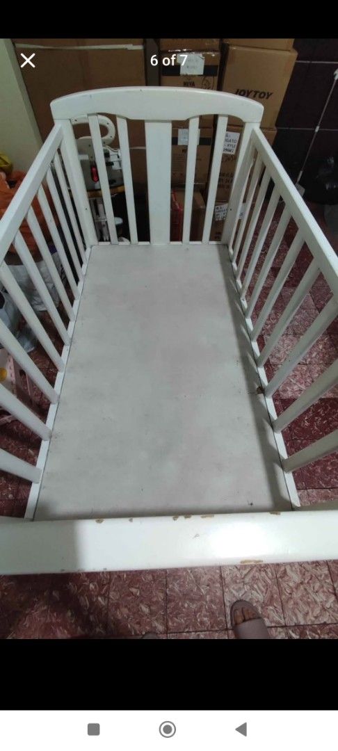 White Wooden Baby Crib (Category: Cots & Cribs) located in Manila. Submitted by sher09461 (Listing ID 1416625807, Image 3). Description: - White wooden baby crib -Crib size is 28" x 48" -Made of Natural Pine Wood - Includes 3" uratex foam mattress 28"x48" - Features vertical slats and curved headboard/footboard - Expect wear and tear on the paint due to usage - Sturdy and suitable for baby -With heavy duty metal caster and stopper so you can move