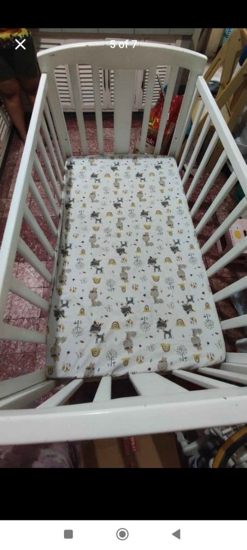 White Wooden Baby Crib (Category: Cots & Cribs) located in Manila. Submitted by sher09461 (Listing ID 1416625807, Image 2). Description: - White wooden baby crib -Crib size is 28" x 48" -Made of Natural Pine Wood - Includes 3" uratex foam mattress 28"x48" - Features vertical slats and curved headboard/footboard - Expect wear and tear on the paint due to usage - Sturdy and suitable for baby -With heavy duty metal caster and stopper so you can move