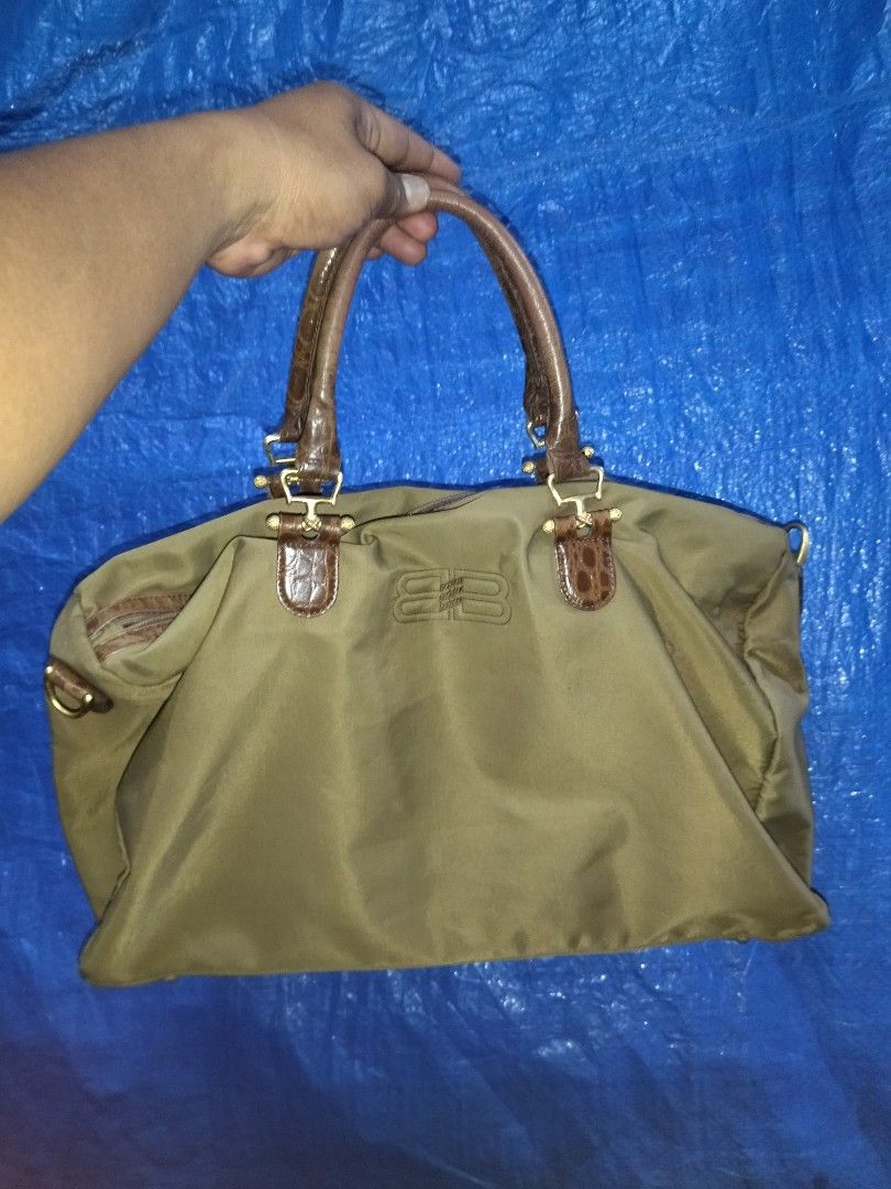 Balenciaga Travel Bag (Category: Luxury Bags & Wallets) located in Bulacan. Submitted by THA_D_THRIFT (Listing ID 1413046696, Image 1). Description: - Balenciaga travel bag - Olive green color - Brown leather handles and accents - Zippered main compartment - Small pocket - Metal logo plate inside - Minor wear on corners - Stylish and functional for travel FRESH FROM JAPAN SOURCE EXCELLENT CONDITION SIGN OF USAGE MINIMAL ISSUE SEE LAST PIC PARANG 
