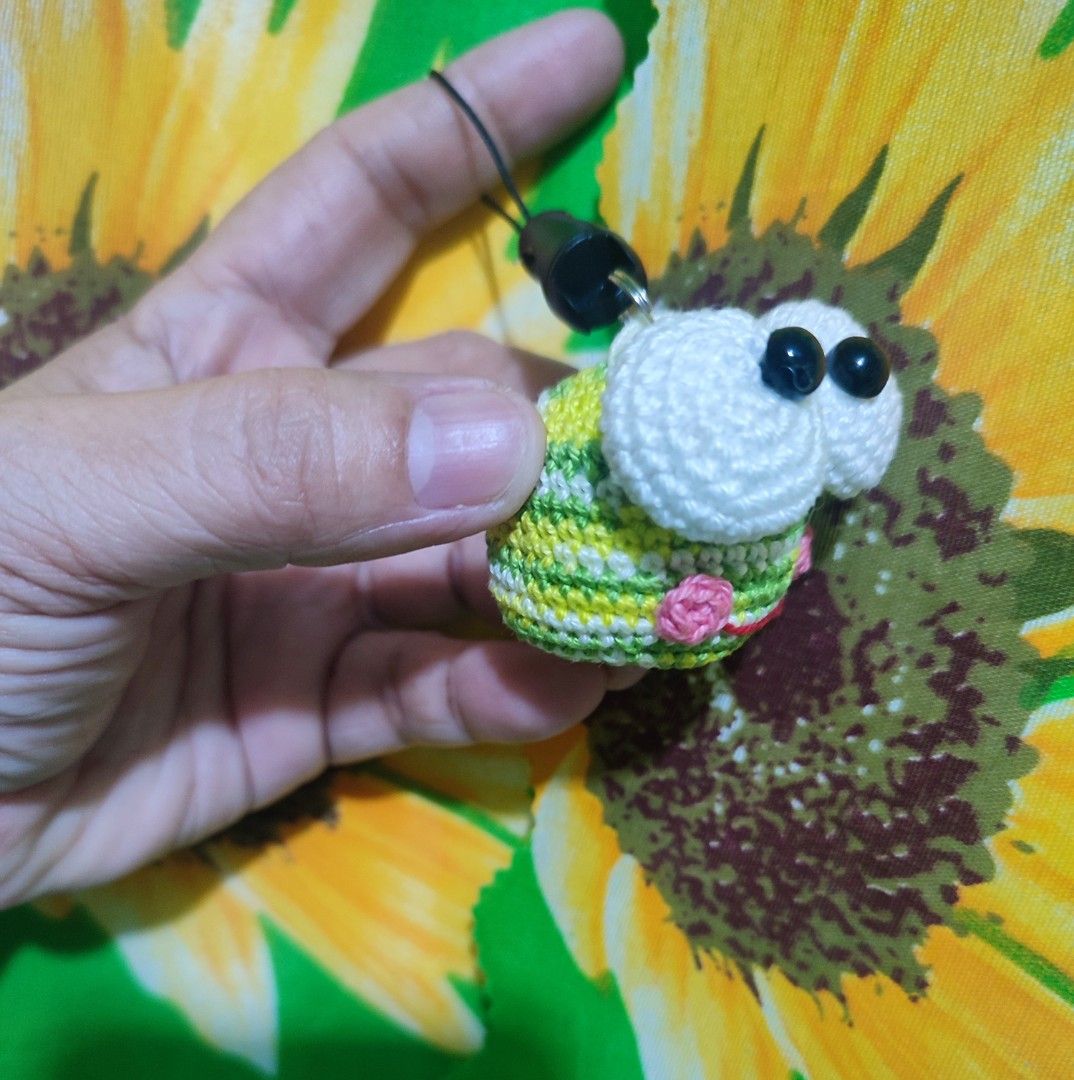 Crochet Frog Keychain/ Phone Charm (Category: Handmade Craft) located in Valenzuela. Submitted by pixieworks64309 (Listing ID 1413046869, Image 2). Description: Handmade crochet frog keychain. Features large white eyes and a colorful body with green, yellow, and pink details. Includes a black string for attaching to keys or bags. A unique and charming accessory..