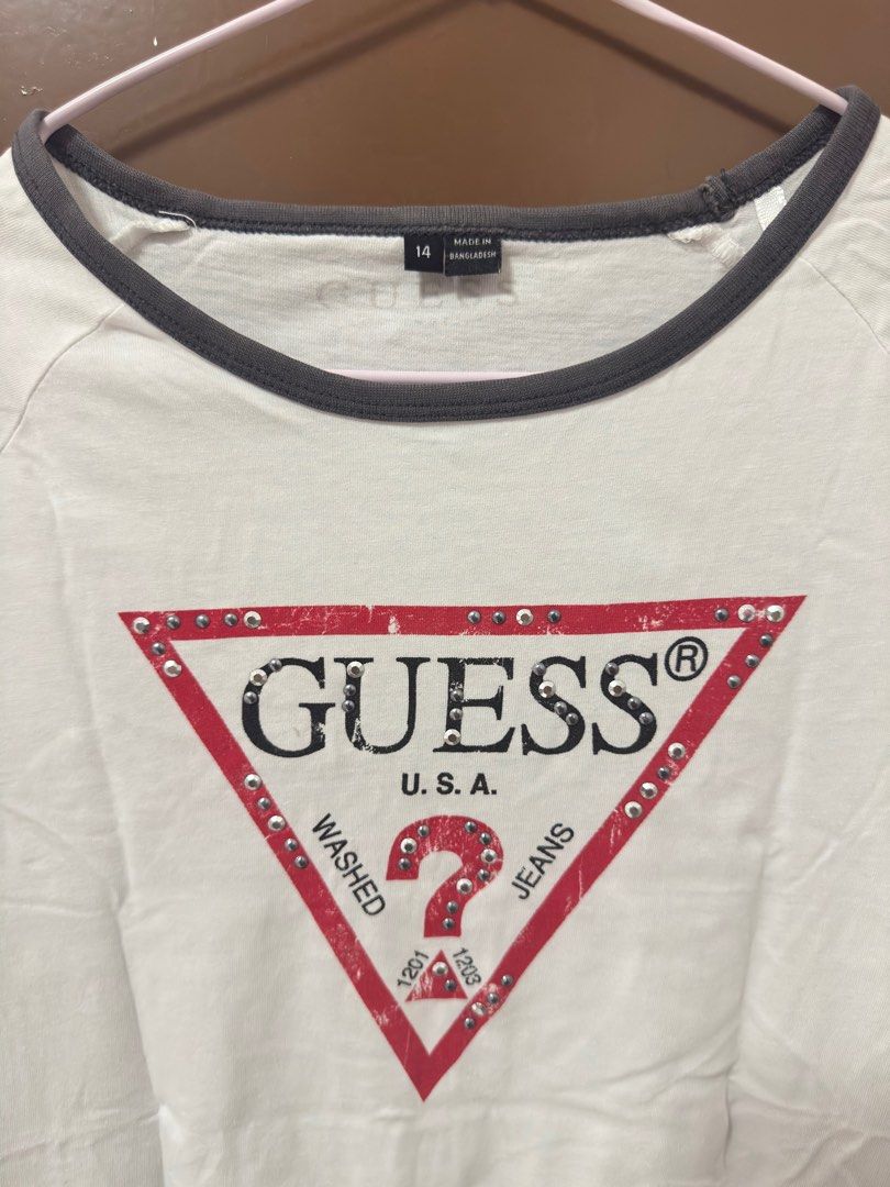 Guess T-shirt with Studded Logo (Category: Shirts) located in Caloocan City. Submitted by shop.ae (Listing ID 1413067526, Image 2). Description: - Guess T-shirt - Red and black studded logo - Round neck with black trim - Short sleeves - Classic design - Ideal for casual wear.