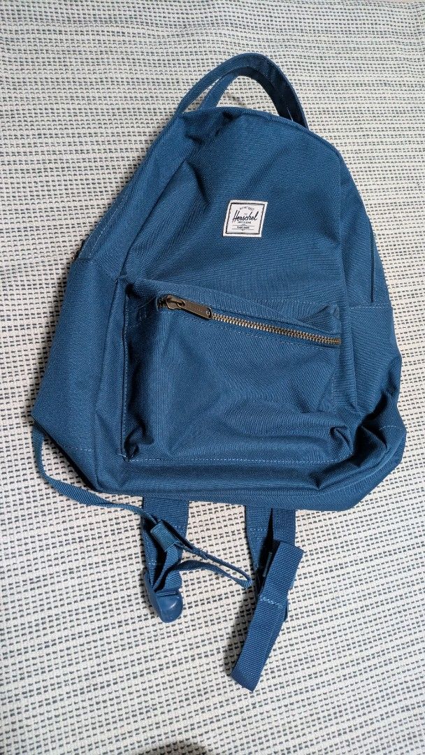 Herschel Nova Mini Backpack - Blue (Category: Backpacks) located in Singapore. Submitted by hazelnut___ (Listing ID 1413164958, Image 1). Description: - Features a front pocket. - Includes a top handle. - Minor stain on image 2..