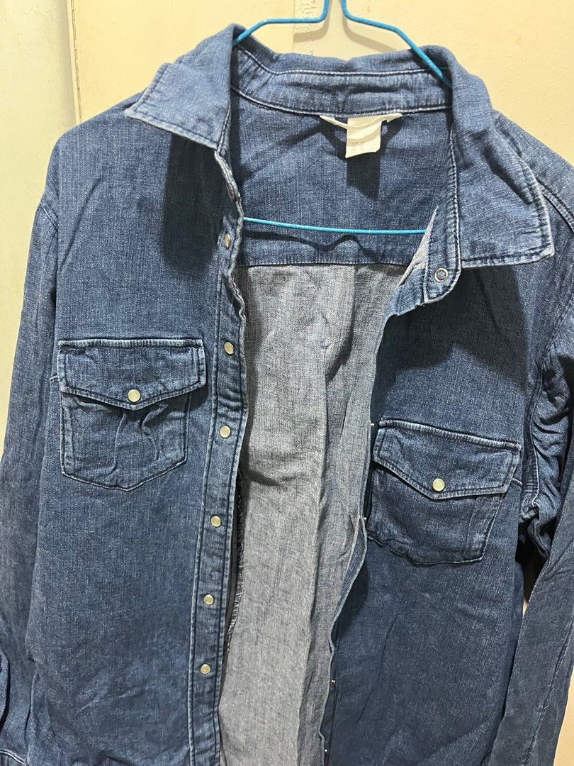 H&M Denim Shirt - Size 16 (Category: Shirts) located in Malabon City. Submitted by hiraethley (Listing ID 1413188964, Image 2). Description: Denim shirt from H&M features a classic design with two chest pockets and snap closures. It has long sleeves and a collared neckline. The shirt is a medium blue wash. The size is EUR 46, US 16, CA 16, CN 175/104A, and MX 16..