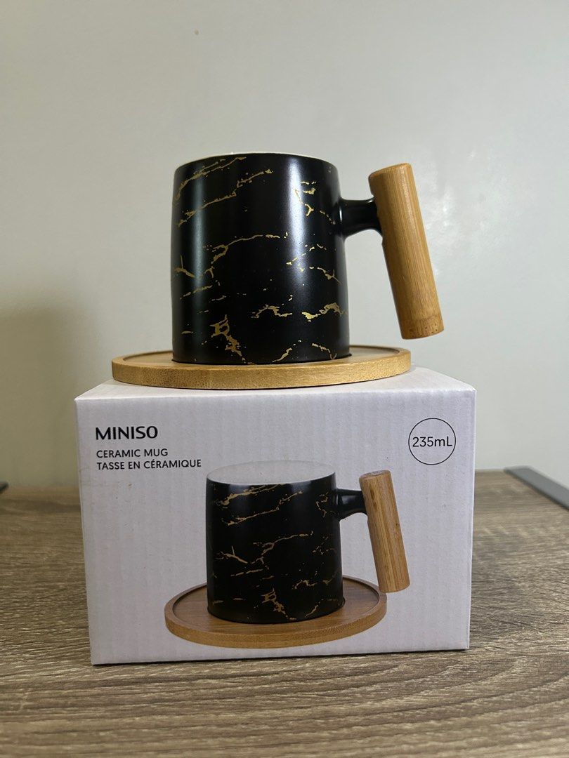 Miniso Ceramic Mug with Wooden Handle (Category: Coffee & Tea Tableware) located in Manila. Submitted by chuakennethh (Listing ID 1413040436, Image 2). Description: - Miniso ceramic mug - Stylish black marble design - Wooden handle and coaster included - 235ml capacity - Brand new, in original packaging - Ideal for hot beverages - Great gift idea.