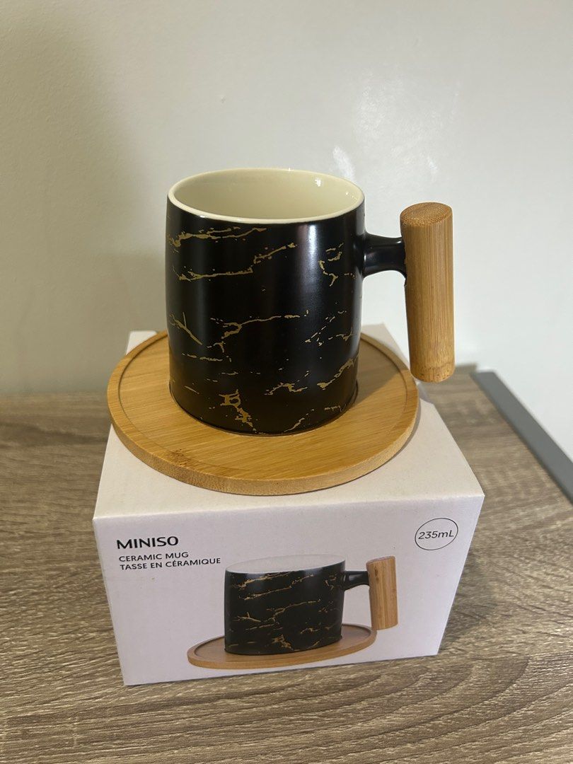 Miniso Ceramic Mug with Wooden Handle (Category: Coffee & Tea Tableware) located in Manila. Submitted by chuakennethh (Listing ID 1413040436, Image 3). Description: - Miniso ceramic mug - Stylish black marble design - Wooden handle and coaster included - 235ml capacity - Brand new, in original packaging - Ideal for hot beverages - Great gift idea.