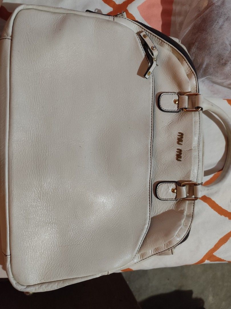 Miu Miu offwhite Handbag (Category: Luxury Bags & Wallets) located in Makati City. Submitted by call_me_biggy (Listing ID 1413104754, Image 1). Description: - Off white Miu Miu handbag - light gold tone hardware - Dual top handles - Zip closure - Exterior zip pockets - Main compartment with brand label - provided sling but not the same brand - Classic shape - Made of leather - Authenticity not guaranteed.