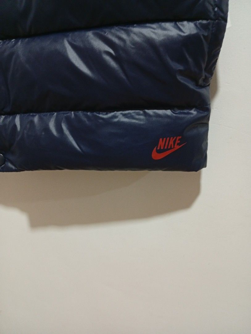 Nike Reversible Puffer Vest (Category: Vests) located in Quezon City. Submitted by mcenon35 (Listing ID 1413195255, Image 2). Description: - Nike reversible vest - Features: Navy blue puffer side & red plaid pattern - Button-up closure - Two pockets on the navy side - Small Nike logo - Size: Medium - Made in China.