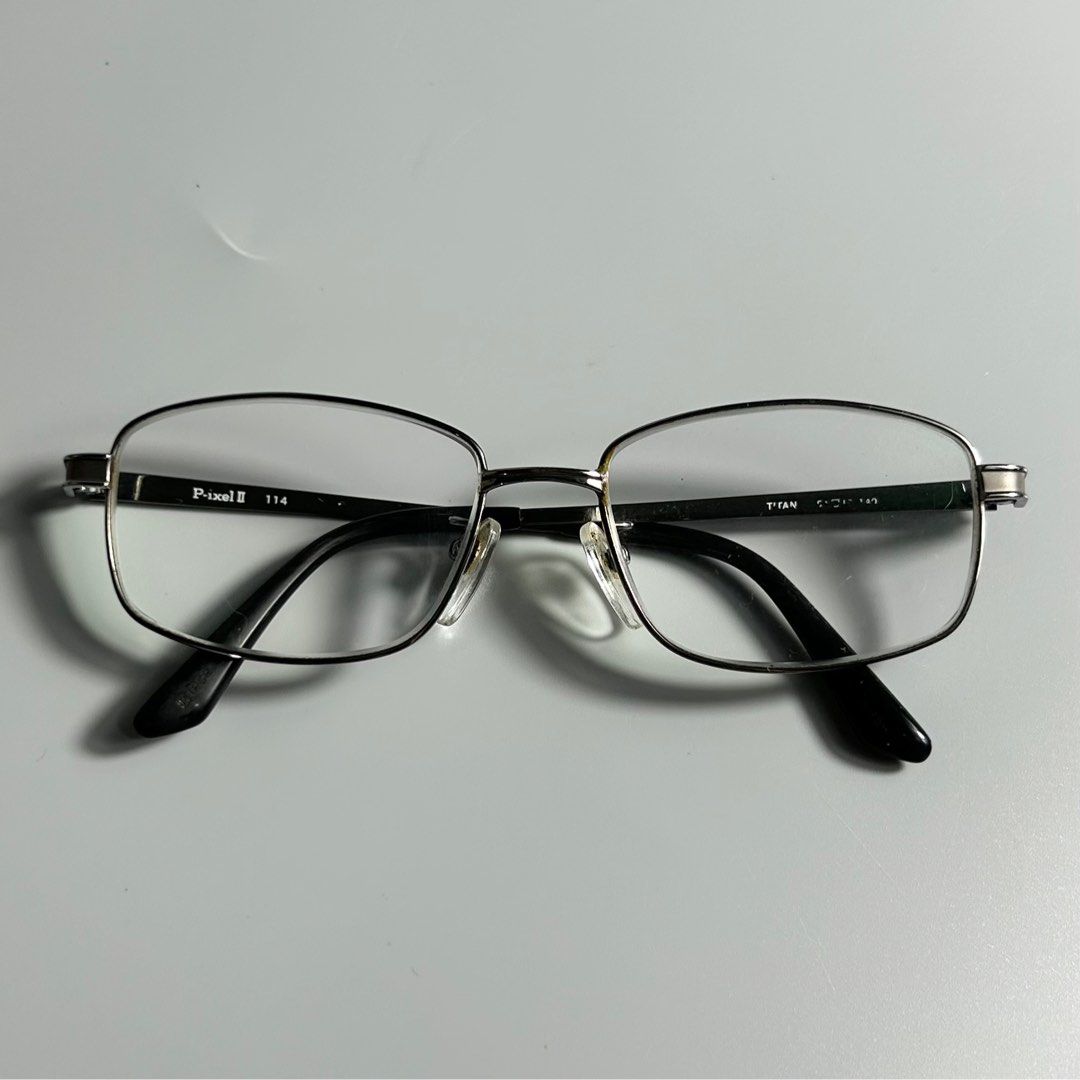 P-ixel II Titanium Eyeglasses (Category: Sunglasses & Eyewear) located in Cavite. Submitted by datsoretro (Listing ID 1413213669, Image 1). Description: - Rectangular frame with a sleek silver finish. - Black temples with "P-ixel II 114" and "Titan 51[]142" markings. - Clear lenses. - Comfortable nose pads. - Modern design suitable for daily wear..