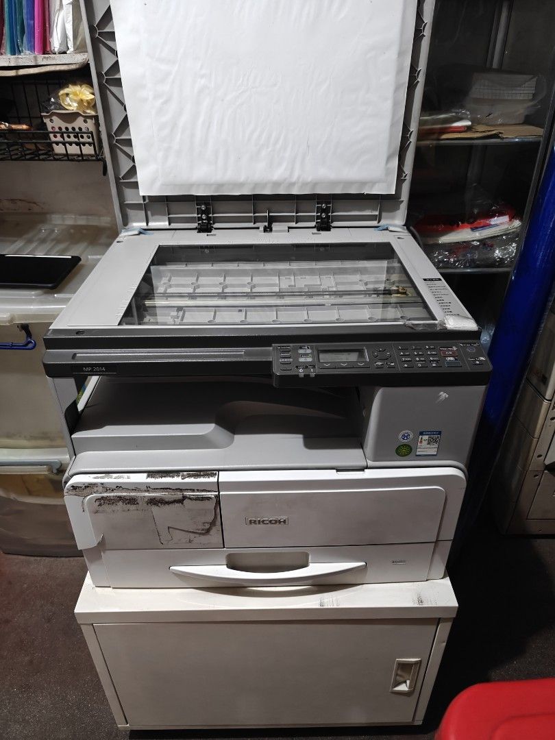 Ricoh Aficio MP 2014 Multifunction Printer (Category: Printers, Scanners & Copiers) located in Manila. Submitted by akintwo023 (Listing ID 1413126221, Image 1). Description: - Ricoh Aficio MP 2014 Multifunction Printer - Scanner and copier functions - Includes paper tray - Features a control panel - Power button and USB port - Flatbed model - Good working condition - Clear photocopy result - Bought Brand-new - Ready to use - included table cabine