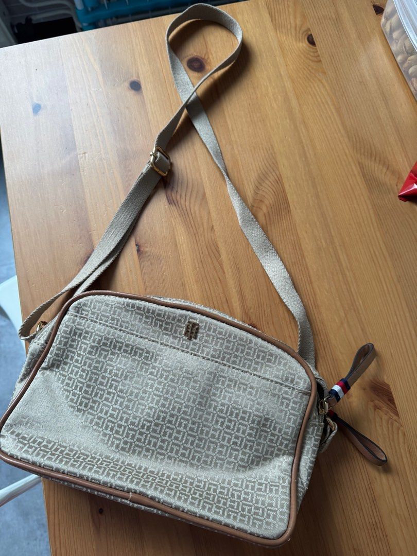 Tommy Hilfiger Crossbody Bag (Category: Cross-body Bags) located in Manila. Submitted by eckastar (Listing ID 1413168788, Image 2). Description: ETA from Germany on May 22,2026 - Tommy Hilfiger crossbody bag - Beige color with repeating logo pattern - Main compartment and front pocket - Adjustable shoulder strap - Small handle with Tommy Hilfiger colors - Brown trim - Gold-colored hardware.
