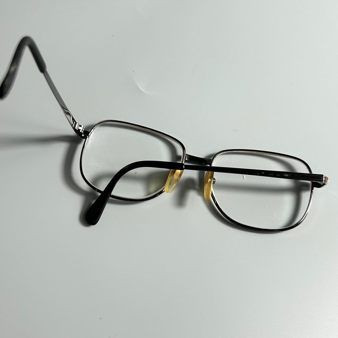 Vintage Titanium Eyeglasses (Category: Sunglasses & Eyewear) located in Cavite. Submitted by datsoretro (Listing ID 1413213637, Image 2). Description: Classic eyeglasses with a silver frame and black temples. The lenses are clear. The frame size is 54[]16-140. The glasses have a rectangular shape. The nose pads are yellow. The temples have a subtle pattern. The glasses are suitable for everyday use..