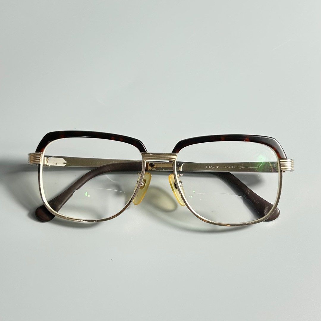 Vintage Tortoiseshell & Titanium Eyeglasses (Category: Sunglasses & Eyewear) located in Cavite. Submitted by datsoretro (Listing ID 1413213651, Image 1). Description: - Vintage Titan-P eyeglasses - Gold-tone frame with brown and tortoise shell accents - Bifocal lenses - Marked "Titan-P 54/17-145" - Made in Japan - Includes nose pads.