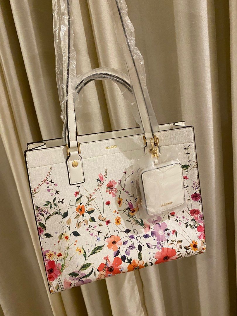 Aldo Floral Tote Bag (Category: Tote Bags) located in Las Pinas. Submitted by mimachay (Listing ID 1416771572, Image 2). Description: - Aldo tote bag - Features a vibrant floral design - Includes a matching small pouch - White base color with colorful floral patterns - New and unused - Still in original packaging.