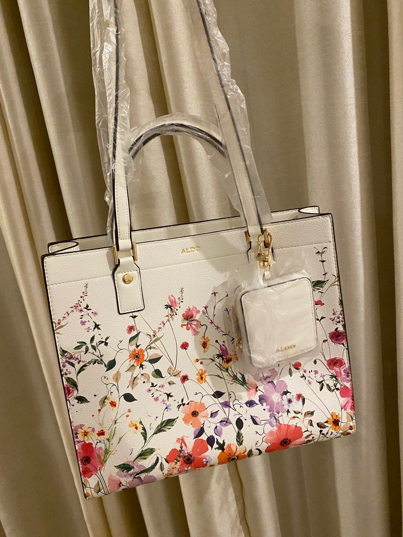 Aldo Floral Tote Bag (Category: Tote Bags) located in Las Pinas. Submitted by mimachay (Listing ID 1416771572, Image 3). Description: - Aldo tote bag - Features a vibrant floral design - Includes a matching small pouch - White base color with colorful floral patterns - New and unused - Still in original packaging.