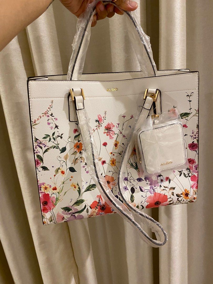 Aldo Floral Tote Bag (Category: Tote Bags) located in Las Pinas. Submitted by mimachay (Listing ID 1416771572, Image 1). Description: - Aldo tote bag - Features a vibrant floral design - Includes a matching small pouch - White base color with colorful floral patterns - New and unused - Still in original packaging.