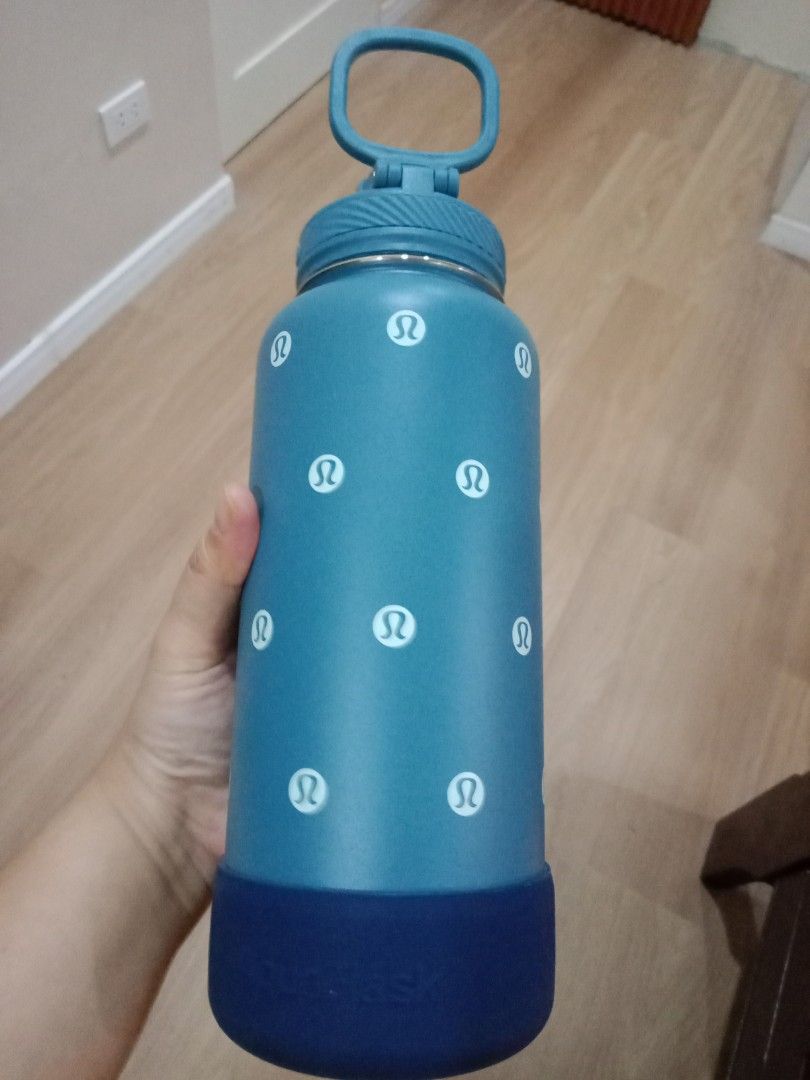 AquaFlask Lululemon Water Bottle (Category: Water Bottles & Tumblers) located in Cebu City. Submitted by monsterheart (Listing ID 1416753847, Image 2). Description: - AquaFlask water bottle - Features Lululemon logo - Teal body with white Lululemon logos - Dark blue base - Teal handle - Flip-top lid - AquaFlask logo on base - Insulated.