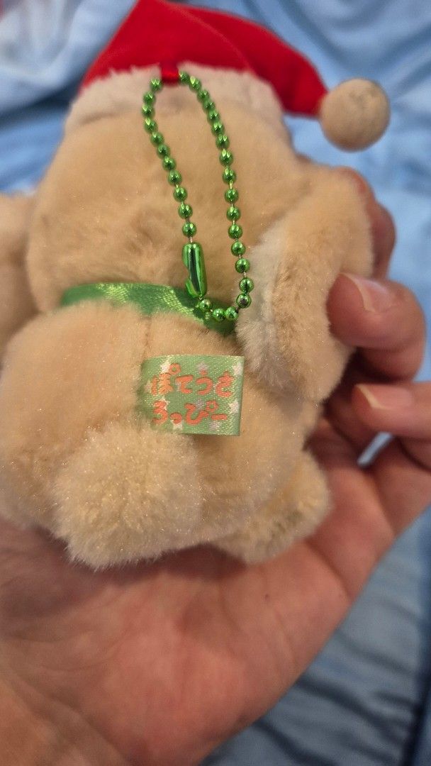 Amuse Christmas Loopy Bunny Plush Charm (Category: Plushies & Soft Toys) located in Quezon City. Submitted by camillechua0221 (Listing ID 1416646391, Image 2). Description: Adorable Loopy bunny wearing a Santa hat and a green ribbon. It has a small tag attached. The bunny is beige in color. It is a cute and festive item, perfect for Christmas decorations or as a gift..